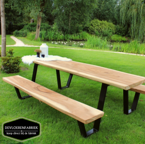 Een picknicktafel van suar hout die gemaakt is door De Vloerenfabriek midden in een park